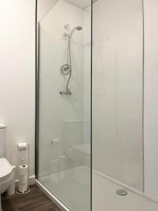 y baño con ducha de cristal y aseo. en Surrey - Private House with Garden & Parking 13, en Wentworth