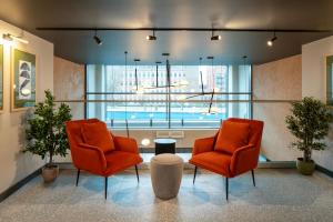 Aparthotel Birmingham في برمنغهام: كرسيان برتقاليان في غرفة مع نافذة كبيرة