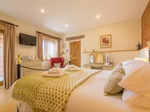een slaapkamer met een bed met twee handdoeken erop bij The Cart Lodge 6 in Great Massingham