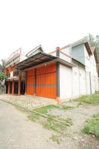 um edifício com uma porta laranja ao lado em SPOT ON 93620 Anisa Homestay Syariah em Tulungagung