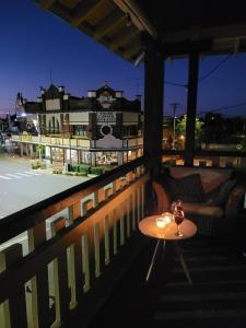 a table on a balcony with a view of a town at The Bank Main Street Apartment in West Wyalong