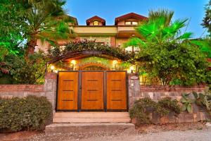 une maison avec une grande porte en bois devant dans l'établissement Kalamos Private villa for 10 people in Hisarönü, à Ölüdeniz