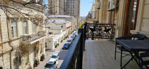 un balcón con coches aparcados en una calle de la ciudad en Pilot hotel Baku center en Bakú