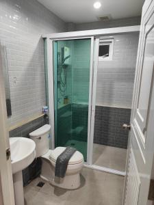 a bathroom with a shower and a toilet and a sink at Hamilton House in Ban Sathani Bandai Ma