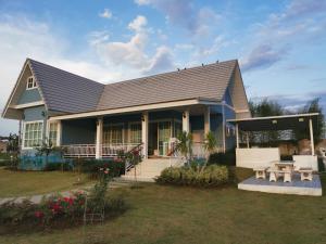 a blue house with a porch and a picnic table at Hamilton House in Ban Sathani Bandai Ma