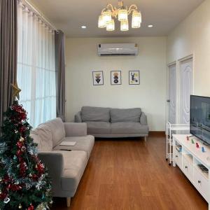a living room with a christmas tree and a couch at Hamilton House in Ban Sathani Bandai Ma