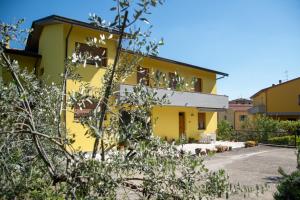 una casa gialla con cortile di Casa Gli Ulivi a Montepulciano