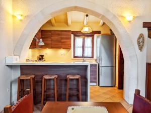 a kitchen with an archway and a table and a refrigerator at Fyllosia Villa Part of Cretan Retreat in Archanes