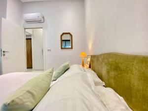 Chez Dadou - joli Apt Marsa Safsaf في المرسى: غرفة نوم مع سرير مع اللوح الأمامي الأخضر