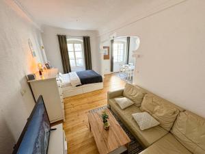 a living room with a couch and a television and a bed at The North Apartment in Ljubljana