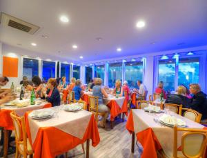 un grupo de personas sentadas en mesas en un restaurante en Hotel Imperamare, en Isquia