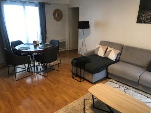 uma sala de estar com um sofá e uma mesa em Paris Neuilly-sur-Seine Appartement bien situé em Neuilly-sur-Seine