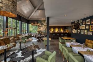 Hotel Restaurant de Echoput في أبلدورن: مطعم ذو كراسي خضراء وطاولات ونوافذ