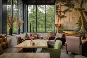ein Restaurant mit Tischen, Stühlen und Fenstern in der Unterkunft Hotel Restaurant de Echoput in Apeldoorn