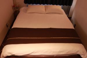 Cama con sábanas y almohadas marrones y blancas en Imperial 心斎橋本町, en Osaka 65 fotos más