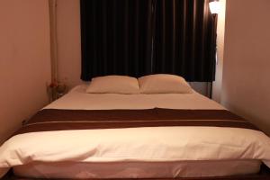 1 dormitorio con 1 cama grande y 2 almohadas en Imperial 心斎橋本町, en Osaka