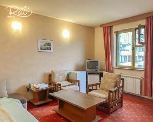 a living room with a couch and a table and a tv at Hotel Rai in Sofia