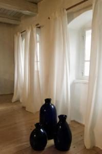 two black vases sitting on a wooden floor next to a window at Poštárova cesta - banícky domček Birnbaum in Hodruša