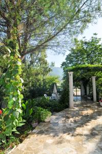 a garden with a patio with a table and chairs at Apartments Villa Stankovic in Tivat