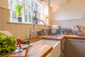 a kitchen with a sink and a window at The Coach House in Flitcham