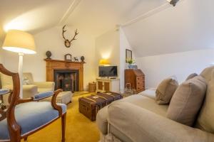 a living room with a couch and a fireplace at The Coach House in Flitcham