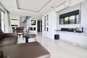 a living room with a couch and a table at Luxury Rooftop Penthouse in Ban Nakhale