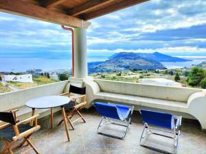 a balcony with chairs and a table and a view at Scirocco Eolie with sea view! in Lipari