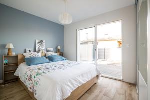1 dormitorio con cama y ventana grande en Douce echappee a Andernos-les-Bains, en Andernos-les-Bains
