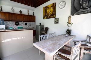 eine Küche mit einem Holztisch und einer Uhr an der Wand in der Unterkunft Belvilla Ananda Resort Lovina BeachNearPantai Lovina in Lovina