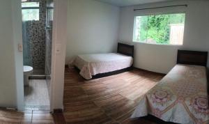 a bedroom with two beds and a window at Casa de praia 2 quartos, 2 banheiros, 1 lavabo, sala, cozinha, Estacionamento para dois carros e a 300m da praia in Angra dos Reis