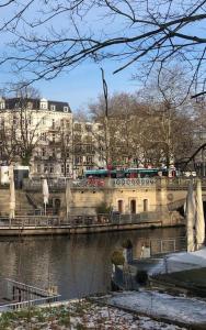 a bridge over a river with a building in the background at Außenalster Penthouse Charakter in Hamburg