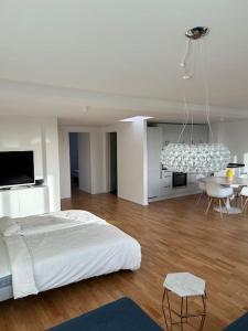 Habitación blanca con cama y lámpara de araña. en Außenalster Penthouse Charakter, en Hamburgo