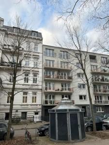 un edificio con un cubo de basura delante de él en Außenalster Penthouse Charakter, en Hamburgo