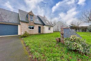 a brick house with a garage in a yard at Maison 4 chambres - Tour du Parc in Le Tour-du-Parc