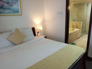 a bedroom with a bed and a bathroom with a tub at Fantastic appartment at times square Kuala Lumpur in Kuala Lumpur