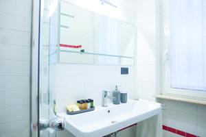 a white bathroom with a sink and a mirror at Suite 52 Trastevere in Rome +27 photos