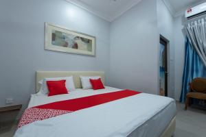 a bedroom with a large white bed with red pillows at Sg Rengit City Resort 2 in Kampung Sungai Rengit