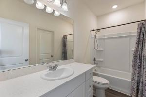 La salle de bains est pourvue d'un lavabo, de toilettes et d'un miroir. dans l'établissement Your cozy home in Brookshire, 