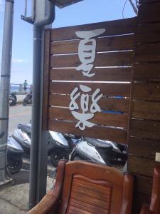 a wooden sign with an asian writing on it next to motorcycles at FUNSUMMER in Green Island