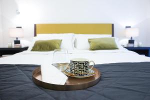 a tray with a cup and a glass on a bed at Suite 52 Trastevere in Rome