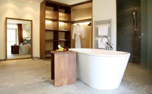 baño grande con bañera y lavamanos en Waldhotel & SPA Davos - for body & soul en Davos