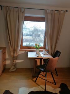 a table and a chair in front of a window at Haus Miriam in Mieming