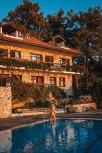 a woman in a swimming pool in front of a building at Faralia Hotel in Faralya