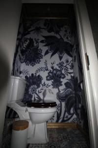 a bathroom with a toilet and a blue and white wallpaper at Chimera House in Brighton & Hove