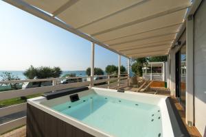 bañera de hidromasaje en el balcón de una casa en Camping Fontanelle, en Moniga del Garda