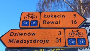 two orange street signs with bikes on them at SANMAR-Całoroczne domki nad morzem w Dziwnówku in Dziwnówek