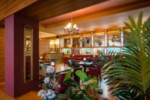 a restaurant with tables and chairs and plants at Raheen Woods Hotel in Athenry