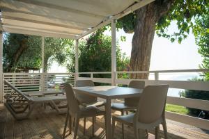 un tavolo e sedie su una terrazza con un albero di Camping Fontanelle a Moniga