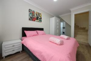 a bedroom with a pink bed with pink pillows on it at Uzay Suite 1 in Istanbul