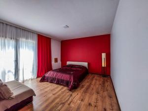 Un dormitorio con una pared roja y una cama. en 4 room house in keda, near Batumi, en K'eda
